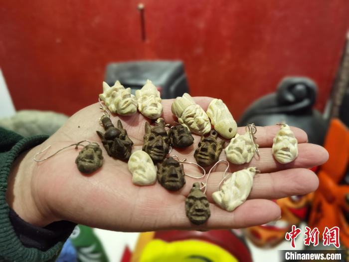 圖為楊云霞制作的儺面具耳環(huán)?！≈苎嗔?攝