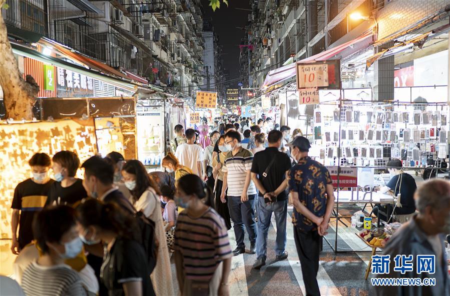 6月1日，市民在武漢保成路夜市消費(fèi)休閑。 隨著復(fù)工復(fù)產(chǎn)復(fù)市持續(xù)推進(jìn)，武漢街頭傳統(tǒng)的夜市再次熱鬧起來，不少市民前來消費(fèi)休閑，初夏的煙火氣充滿生機(jī)。 新華社記者 熊琦 攝