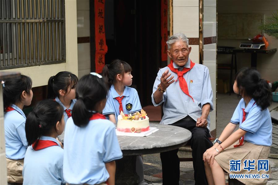 6月28日，吳興區(qū)第一小學(xué)學(xué)生聆聽八里店鎮(zhèn)前村村老黨員陳金茂（右二）講故事。 臨近“七一”，浙江省湖州市吳興區(qū)八里店鎮(zhèn)組織小學(xué)生開展“童心向黨”主題繪畫、聆聽老黨員講故事、參觀紅色教育基地等活動(dòng)。 新華社記者黃宗治攝
