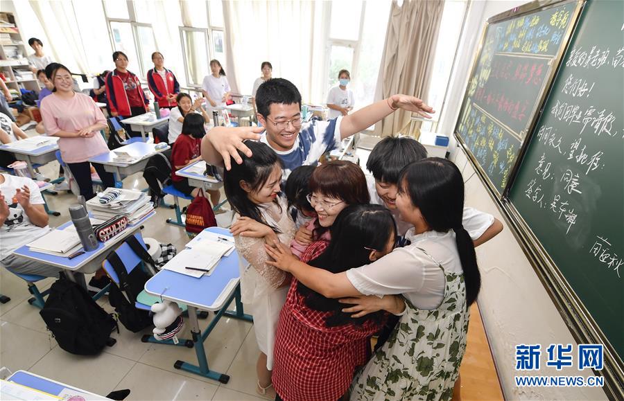 7月6日，吉林省孤兒學(xué)校高三年級學(xué)生與班主任吳東輝相擁慶祝畢業(yè)。 新華社記者 許暢 攝