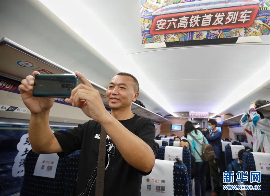 7月8日，在六盤水首發(fā)高鐵G2954次列車上，一名乘客拍照留念。 當(dāng)日，安六高鐵（安順至六盤水）正式開通運營，貴州六盤水市全面接入全國高鐵網(wǎng)。 新華社記者 劉續(xù) 攝