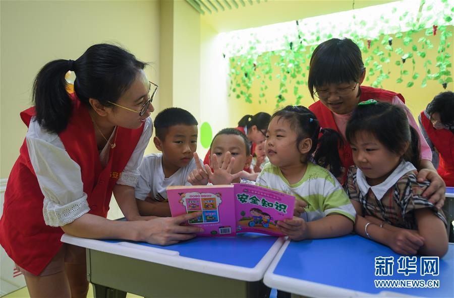 7月9日，在杭州市臨安區(qū)一幼兒園的暑托班，錦城街道勝利社區(qū)的青年社工向小朋友們講解安全知識繪本。新華社記者 徐昱 攝