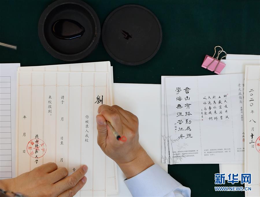8月13日，陜西師范大學(xué)在職教師王雙懷書寫錄取通知書。 當(dāng)日，陜西師范大學(xué)2020年手寫錄取通知書正式開筆。該校自2007年起采用毛筆書寫錄取通知書的方式，為新生傳遞佳音。今年，學(xué)校十余位退休教師、在職教師、校友代表等書法愛好者將為約4500名新錄取的本科生送上帶著墨香的大學(xué)錄取通知書。 新華社記者 張博文 攝