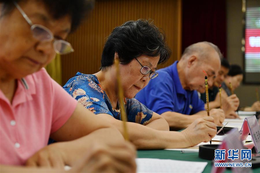 8月13日，陜西師范大學(xué)退休教師韓月娥（左二）等書寫錄取通知書。 當(dāng)日，陜西師范大學(xué)2020年手寫錄取通知書正式開筆。該校自2007年起采用毛筆書寫錄取通知書的方式，為新生傳遞佳音。今年，學(xué)校十余位退休教師、在職教師、校友代表等書法愛好者將為約4500名新錄取的本科生送上帶著墨香的大學(xué)錄取通知書。 新華社記者 張博文 攝