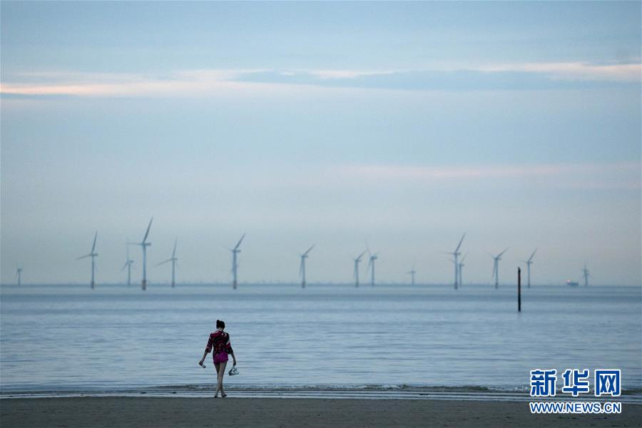 9月14日，一名女子在英國克羅斯比海邊休閑。 根據(jù)英國首相約翰遜宣布的疫情防控新舉措，自9月14日起，除少數(shù)情況外，日常社交場合中的聚集人數(shù)不得超過6人，室內(nèi)室外均適用，違者可能面臨罰款等處罰。不過，學(xué)校和工作場合等并不受影響。 新華社發(fā)（喬恩·休珀攝）