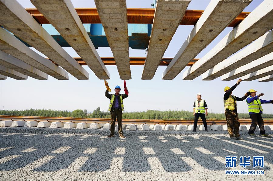 10月5日，在中鐵二局等單位承建的水曹鐵路施工現(xiàn)場(chǎng)，鐵路建設(shè)者在河北唐山灤州茨榆坨鎮(zhèn)進(jìn)行鋪軌作業(yè)。水曹鐵路位于唐山市境內(nèi)，本線北端接軌卑水線可達(dá)首鋼水廠礦區(qū)，南端直達(dá)曹妃甸港區(qū)礦石碼頭和通用碼頭。 國(guó)慶、中秋“雙節(jié)”期間，全國(guó)各地依然有建設(shè)者在工地一線施工，確保各建設(shè)工程穩(wěn)步推進(jìn)。 新華社記者 牟宇 攝