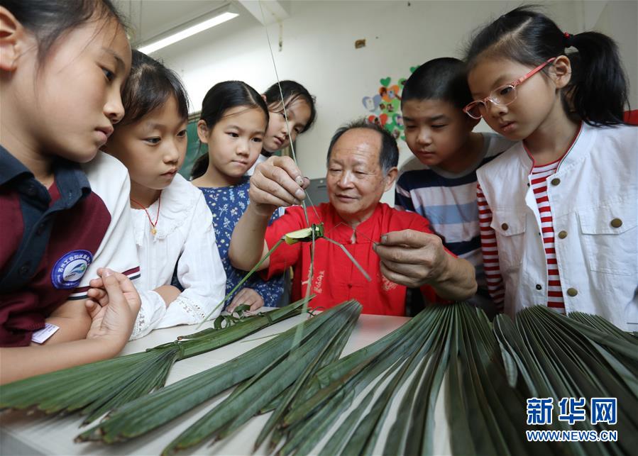 10月9日，民間藝人在蘇州工業(yè)園區(qū)星海小學(xué)向孩子們講解棕編技藝。 當(dāng)日，江蘇蘇州工業(yè)園區(qū)星海小學(xué)開(kāi)展“傳統(tǒng)文化手工制作體驗(yàn)“活動(dòng)，孩子們?cè)诋?dāng)?shù)厥止に嚾说闹笇?dǎo)下，學(xué)習(xí)剪紙、棕編等手工技藝，感受傳統(tǒng)文化。 新華社發(fā)（杭興微 攝）