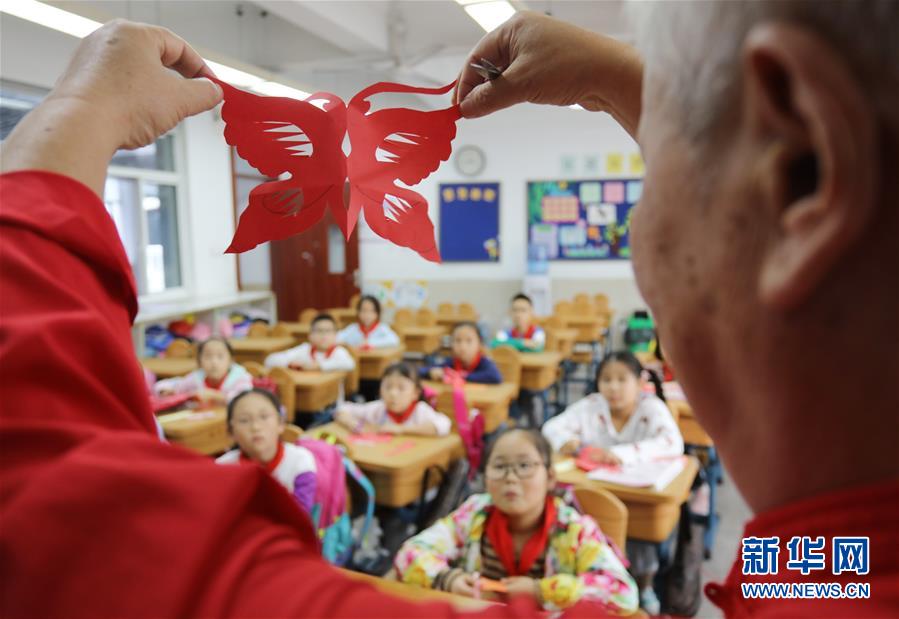 10月9日，民間藝人在蘇州工業(yè)園區(qū)星海小學(xué)向孩子們講解剪紙技藝。 當(dāng)日，江蘇蘇州工業(yè)園區(qū)星海小學(xué)開(kāi)展“傳統(tǒng)文化手工制作體驗(yàn)“活動(dòng)，孩子們?cè)诋?dāng)?shù)厥止に嚾说闹笇?dǎo)下，學(xué)習(xí)剪紙、棕編等手工技藝，感受傳統(tǒng)文化。 新華社發(fā)（杭興微 攝）