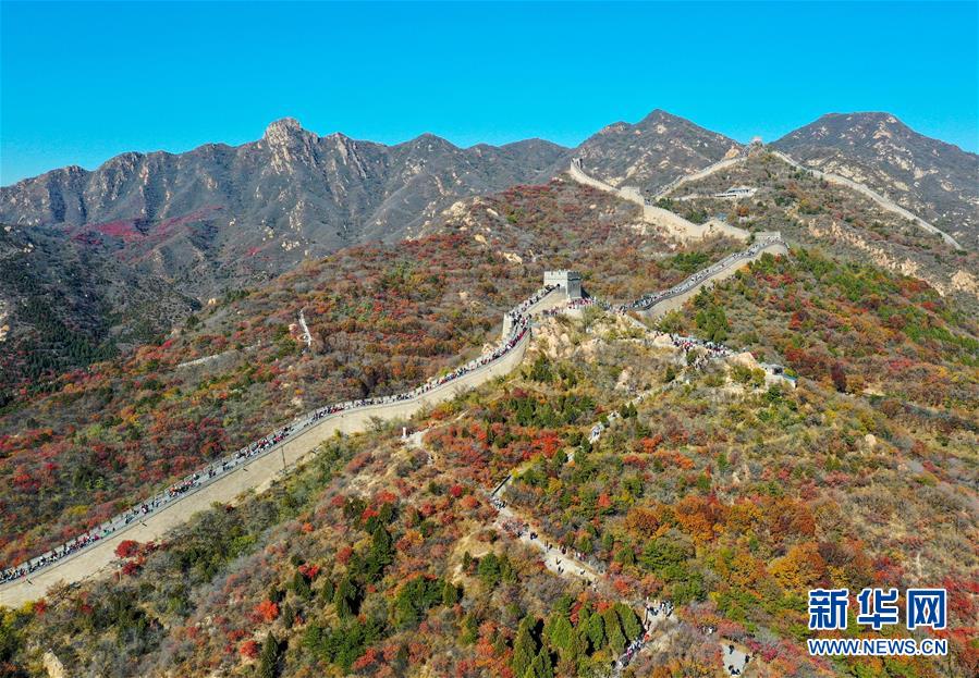 10月24日，游人在八達(dá)嶺長城游覽（無人機(jī)照片）。 深秋時(shí)節(jié)，北京八達(dá)嶺長城紅葉進(jìn)入最佳觀賞期，紅葉映長城美如畫卷。 新華社記者 陳曄華 攝