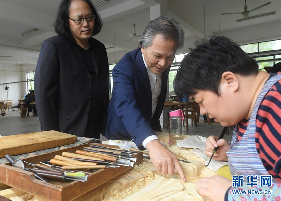 亞太地區(qū)手工藝大師、中國工藝美術(shù)大師陸光正（中）在其創(chuàng)作室內(nèi)和工作人員交流雕刻細(xì)節(jié)（10月19日攝）。新華社記者 翁忻旸 攝