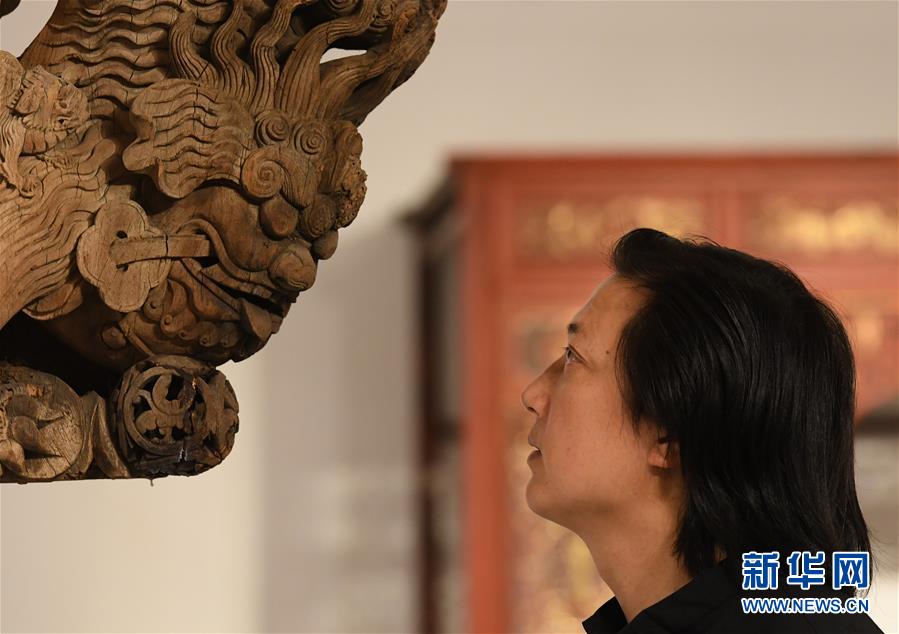 浙江省工藝美術(shù)大師陳國華在工作室觀察收藏的老木雕建筑構(gòu)件的細(xì)節(jié)（10月20日攝）。 新華社記者 翁忻旸 攝