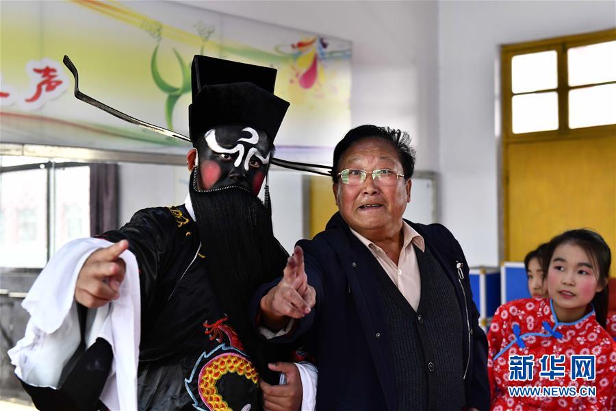 10月28日，在棗莊市臺兒莊區(qū)西關(guān)小學(xué)，文藝志愿者馬永法（中）在指導(dǎo)小學(xué)員。新華社記者 郭緒雷 攝