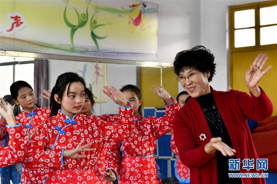 10月28日，在棗莊市臺兒莊區(qū)西關(guān)小學(xué)，文藝志愿者張鳳云在指導(dǎo)小學(xué)員練身段。新華社記者 郭緒雷 攝