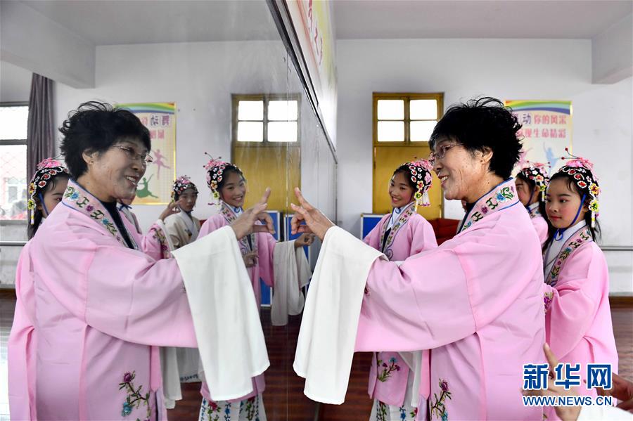 10月28日，在棗莊市臺兒莊區(qū)西關(guān)小學(xué)，文藝志愿者張鳳云在指導(dǎo)小學(xué)員練身段。新華社記者 郭緒雷 攝