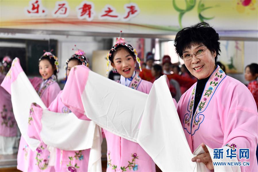 10月28日，在棗莊市臺兒莊區(qū)西關(guān)小學(xué)，文藝志愿者張鳳云在指導(dǎo)小學(xué)員練身段。新華社記者 郭緒雷 攝