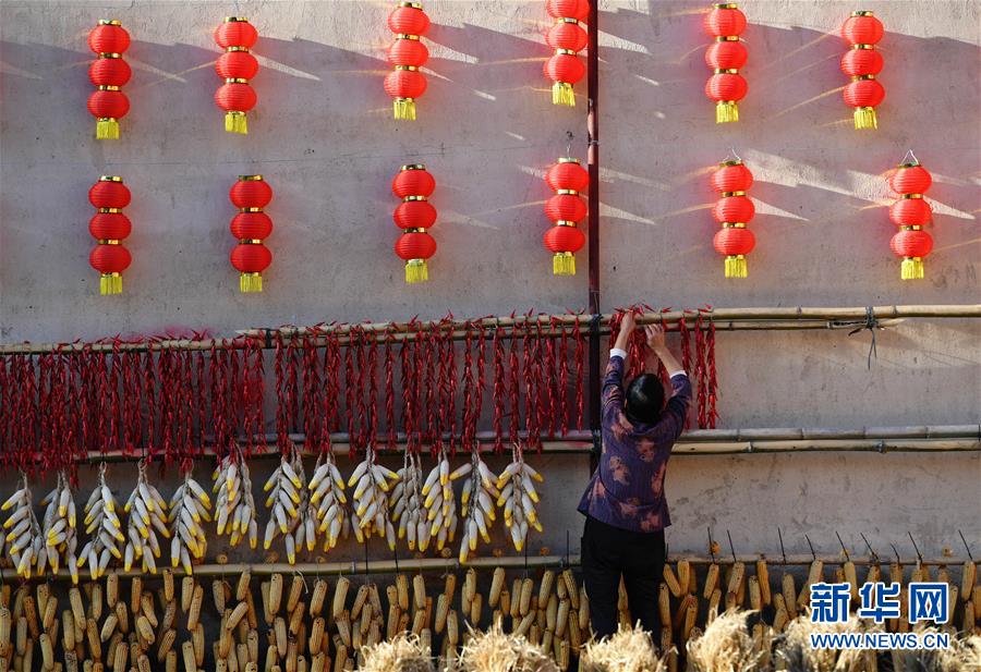 11月1日，一名村民在整理曬架上的農(nóng)作物。 深秋時(shí)節(jié)，位于福建省三明市尤溪縣洋中鎮(zhèn)的桂峰村，古民居與曬匾里五彩繽紛的農(nóng)作物，構(gòu)成五彩斑斕的調(diào)色板，展現(xiàn)秋收風(fēng)情。 新華社記者魏培全攝