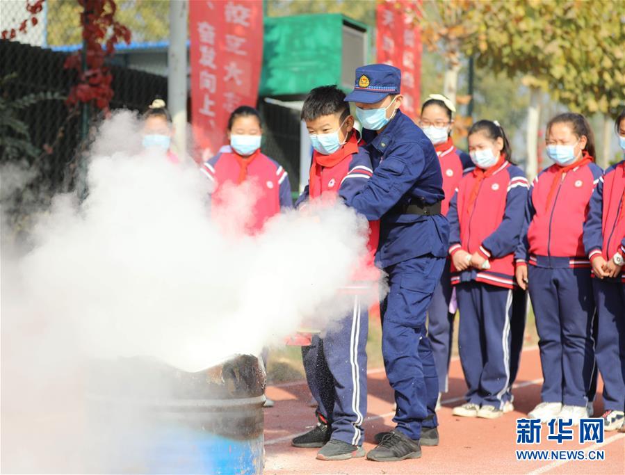 11月4日，固安縣第七小學(xué)學(xué)生在消防救援人員的指導(dǎo)下學(xué)習(xí)使用滅火器滅火。 當(dāng)日，河北省固安縣消防救援大隊(duì)開展“119消防安全教育進(jìn)校園”主題宣傳活動(dòng)。通過消防演練、消防裝備展示、消防互動(dòng)體驗(yàn)、宣講消防安全知識、講解滅火器材使用方法等，進(jìn)一步提高學(xué)生的消防安全意識和逃生自救能力。 新華社發(fā)（門叢碩 攝）