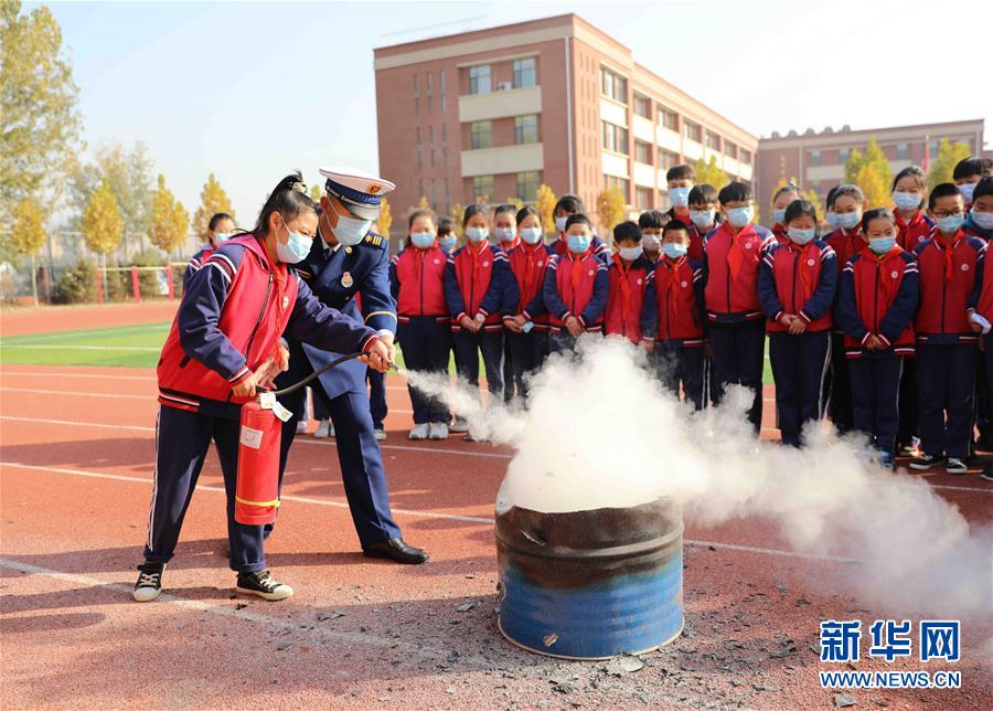 11月4日，固安縣第七小學(xué)學(xué)生在消防救援人員的指導(dǎo)下學(xué)習(xí)使用滅火器滅火。 當(dāng)日，河北省固安縣消防救援大隊(duì)開展“119消防安全教育進(jìn)校園”主題宣傳活動(dòng)。通過消防演練、消防裝備展示、消防互動(dòng)體驗(yàn)、宣講消防安全知識、講解滅火器材使用方法等，進(jìn)一步提高學(xué)生的消防安全意識和逃生自救能力。 新華社發(fā)（門叢碩 攝）