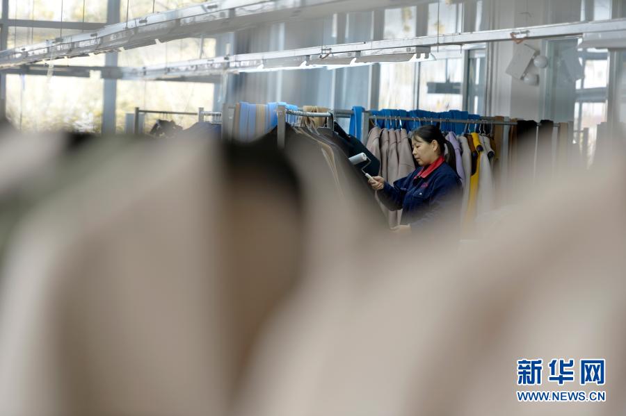 11月11日，清河縣一家羊絨制品生產(chǎn)企業(yè)的員工整理羊絨大衣。新華社記者 牟宇 攝