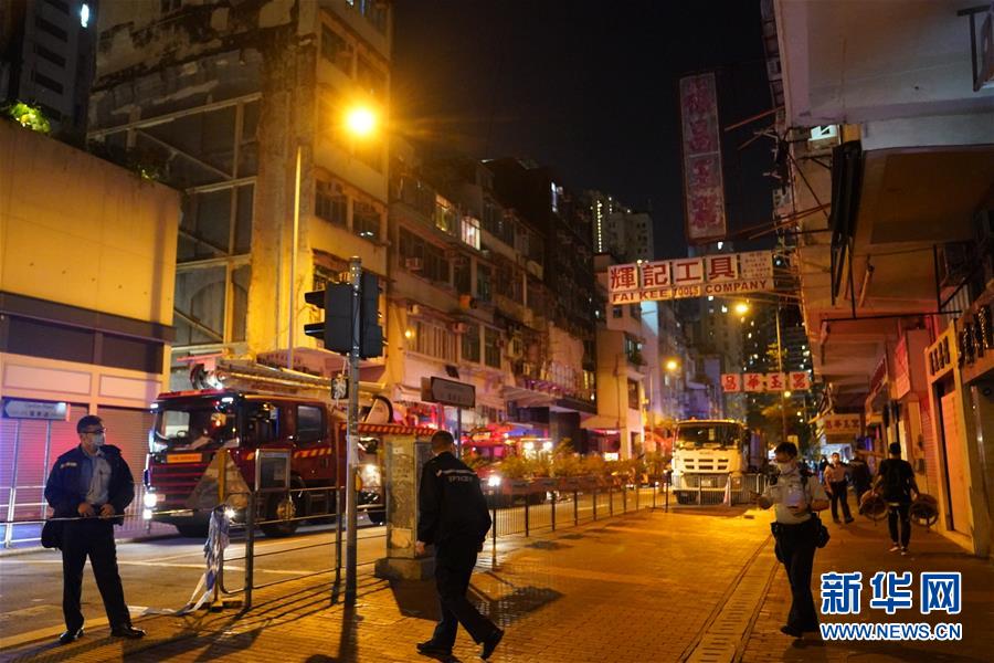 11月15日，消防員和警察在火災(zāi)現(xiàn)場調(diào)查。 香港九龍佐敦廣東道560號一座老式居民樓15日夜起火。香港特區(qū)政府新聞處向新華社記者證實，火災(zāi)已經(jīng)造成17人被送醫(yī)院搶救，截至零點有7人遇難、10人受傷。 新華社記者 呂小煒 攝