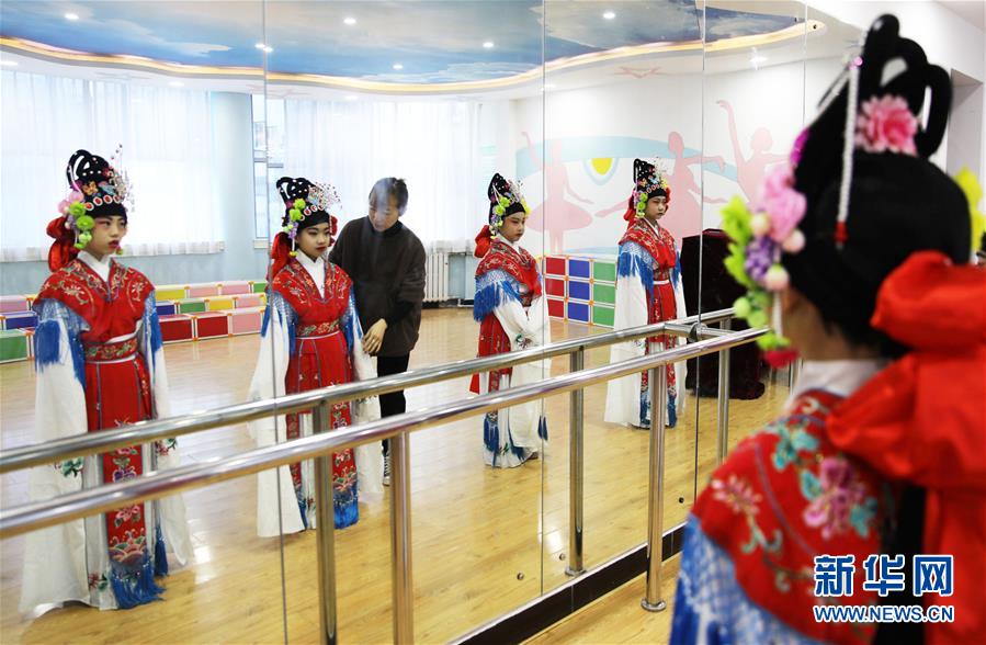 12月22日，在承德市雙橋區(qū)魁星園小學(xué)京劇課堂，學(xué)生在老師的指導(dǎo)下進(jìn)行形體訓(xùn)練。 河北省承德市雙橋區(qū)魁星園小學(xué)是一所京劇藝術(shù)教育特色學(xué)校，榮獲“全國中小學(xué)中華優(yōu)秀文化藝術(shù)傳承學(xué)?！狈Q號(hào)。該校將京劇作為校本課程納入學(xué)校課程表，學(xué)校組織力量自編教材，聘請(qǐng)專業(yè)教師為學(xué)生上課，教授京劇表演技藝和經(jīng)典唱段，讓孩子們“學(xué)起來”“唱出來”“舞起來”，感受傳統(tǒng)戲曲文化的魅力。 新華社發(fā)（劉環(huán)宇 攝）