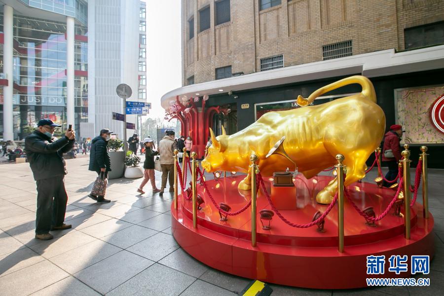 　　2月7日，市民在南京路步行街旁拍攝金牛雕塑。　　春節(jié)將至，上海市節(jié)日氛圍日漸濃厚。人們紛紛外出感受春意，采購(gòu)年貨，迎接新年?！　⌒氯A社記者 王翔 攝