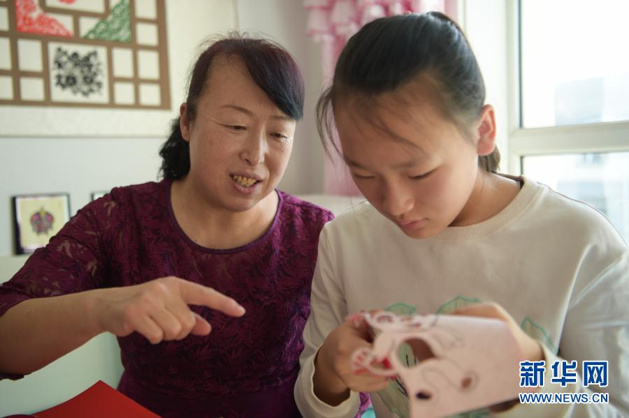 　　2月21日，在烏海市海南區(qū)新橋花園，李華（左）在家中指導(dǎo)外孫女高宇晨剪紙?！　〗衲?6歲的李華家住內(nèi)蒙古自治區(qū)烏海市海南區(qū)新橋花園，受長輩影響從小就開始剪紙。在李華引導(dǎo)下，她的大女兒譚紅葉也愛上了剪紙，經(jīng)常與李華探討創(chuàng)新剪紙技藝的想法?，F(xiàn)在，李華的外孫女高宇晨也向她們學(xué)習(xí)剪紙技藝，已經(jīng)能獨(dú)立創(chuàng)作剪紙作品?！　±钊A堅持剪紙40多年，創(chuàng)作了豐富的剪紙作品。為了傳承剪紙技藝，李華除了教授女兒、外孫女剪紙，還參加剪紙展覽、教學(xué)等活動，帶動更多的人學(xué)習(xí)、傳承剪紙技藝?！　〗衲甏汗?jié)，李華一家三代人一起剪紙，用不同的作品迎接新春?！拔蚁胪ㄟ^我們?nèi)说慕恿?，帶動親人朋友學(xué)習(xí)剪紙，讓剪紙技藝傳承下去。”李華說。　　新華社記者 李志鵬 攝