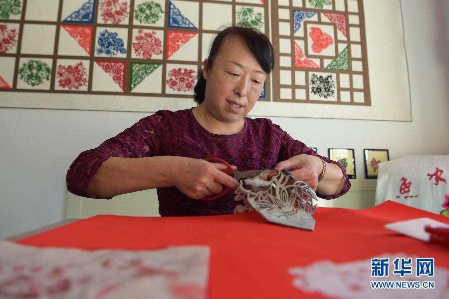 　　2月21日，在烏海市海南區(qū)新橋花園，李華在家中剪紙。新華社記者 李志鵬 攝
